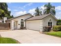 Attractive home exterior featuring an attached garage, arched windows, and lush landscaping in a green neighborhood at 1891 Bryan Ave, Winter Park, FL 32789
