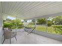 Relaxing screened porch with hammock, chair, and table with a view of the front yard at 224 Woodmere Blvd, Sanford, FL 32773