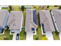 An aerial view showing a house with solar panels between two similar homes in a suburban neighborhood at 2249 Litchfield Loop, Deland, FL 32720
