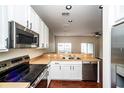 Modern kitchen features stainless steel appliances, white cabinets, and hardwood floors at 2337 Bexley Pl, Casselberry, FL 32707