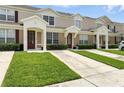 Two-story townhome featuring a well-manicured lawn at 2409 Silver Palm Dr, Kissimmee, FL 34747