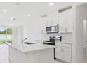 Bright kitchen features white cabinets, stainless steel appliances and a large kitchen island with sink at 2770 Virginia Pine Dr, Bartow, FL 33830