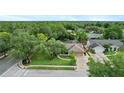 An aerial view of a charming home with a well-maintained lawn, surrounded by lush greenery and a peaceful neighborhood at 283 Haverclub Ct, Longwood, FL 32779