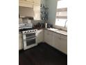 Updated kitchen features granite countertops, modern appliances, and stainless steel range hood at 310 W Lake Ave, Auburndale, FL 33823