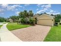 Paver driveway leads to a well-maintained home with a two-car garage at 3896 Esplanade Ave, Port Orange, FL 32129