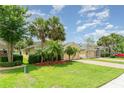 Landscaped front yard showcasing lush green grass and mature trees with a brick driveway at 3896 Esplanade Ave, Port Orange, FL 32129