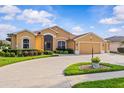 Inviting home with a manicured front yard and a spacious driveway leading to an attached garage at 5339 Pond Crossing Pl, Leesburg, FL 34748