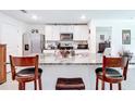 Open kitchen with granite countertops, stainless steel appliances, and barstool seating at 7161 Sw 135Th Pl, Ocala, FL 34473
