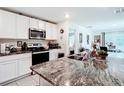Bright kitchen featuring granite countertops, stainless steel appliances, and white cabinetry at 7161 Sw 135Th Pl, Ocala, FL 34473