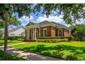 Elegant brick home with classic columns, manicured hedges, and a lush green lawn at 922 Jasmine St, Celebration, FL 34747