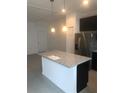 Kitchen with island and granite countertops, stainless steel appliances and neutral colors, and modern lighting fixtures at 1003 E 10 St, Apopka, FL 32703