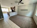 Open-concept living space with a carpeted floor and a view of the kitchen area at 12359 Langstaff Dr, Windermere, FL 34786