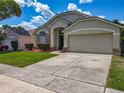 Charming single-Gathering home featuring a well-manicured lawn and an attached two-car garage at 12938 Maribou Cir, Orlando, FL 32828
