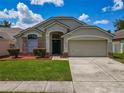 Charming single-Gathering home featuring a well-manicured lawn and an attached two-car garage at 12938 Maribou Cir, Orlando, FL 32828