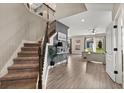 Open-concept living with a staircase, wood floors, and an open view of the living room with ample natural light at 1409 Bellamy Dr, Reunion, FL 34747