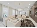 Bright, expansive living room with marble floors, stylish decor, a mirrored wall, and ample seating at 17551 Black Rail St, Windermere, FL 34786