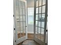 Home office with natural light streaming through the window, and glass doors leading to hallway at 2042 Key Bay Trl, Kissimmee, FL 34747