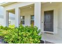 Inviting front porch with rocking chairs, decorative shrubbery, and a welcoming front door at 2149 Tudor Rose Dr, Sanford, FL 32773