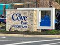 Stone sign for 'The Cove East at Storey Lake' community, surrounded by lush greenery at 2665 Petition Ln, Kissimmee, FL 34746