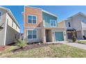 Modern two-story home with colorful siding, one car garage and a beautifully landscaped front yard at 2665 Petition Ln, Kissimmee, FL 34746