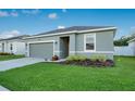 A cozy single-story house showcases a green lawn and an attached two-car garage at 3408 Curlew Ave, Leesburg, FL 34748