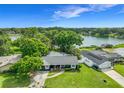 Desirable lakefront property with lush surroundings, solar panels, a well-manicured yard, and mature trees at 3417 Pershing Ave, Orlando, FL 32812