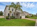 Charming two-story house featuring a lush lawn, two-car garage, and beautiful landscaping with mature palm trees at 3472 Gretchen Dr, Ocoee, FL 34761