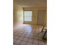 A well-lit living room with tile flooring, a front door, and a window providing natural light at 3700 Washington St, Sanford, FL 32771
