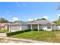 Inviting single-story home featuring a lush green lawn and an attached two-car garage at 5409 Holtland Dr, Apopka, FL 32712