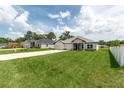 Nice view of the community with manicured lawn and lengthy driveway at 5908 Sw 115 Street Rd, Ocala, FL 34476