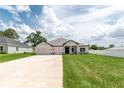 Charming one-story home featuring a spacious driveway, lawn, and inviting curb appeal at 5908 Sw 115 Street Rd, Ocala, FL 34476
