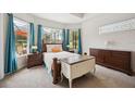 Bright main bedroom with bay windows overlooks the screened pool area and has stylish furnishings at 748 Mills Estate Pl, Chuluota, FL 32766