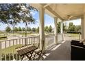 Spacious covered balcony with ceiling fan featuring a small table and comfortable outdoor seating with park views at 7509 Mourning Dove Cir # 204, Reunion, FL 34747