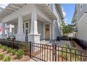 Inviting two-story home with a cozy front porch and well-manicured landscaping and black metal fence at 923 Colie Aly, Winter Garden, FL 34787