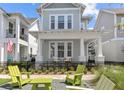Inviting two-story home with rocking chairs on the porch and an outdoor seating area at 923 Colie Aly, Winter Garden, FL 34787