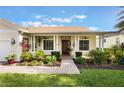Inviting front porch with white pillars and ceiling fans, surrounded by lush landscaping at 930 Willow Oak Loop, Minneola, FL 34715