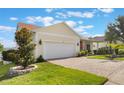 Home with a two-car garage, brick paved driveway, and well-maintained front yard at 930 Willow Oak Loop, Minneola, FL 34715