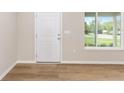 Bright entryway featuring a window, white door, neutral walls, and stylish wood-look flooring at 1059 Ne 130Th Ter, Silver Springs, FL 34488