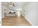Bright open-plan living room with vaulted ceiling, ceiling fan, and modern wood-look flooring at 1059 Ne 130Th Ter, Silver Springs, FL 34488