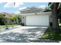 Traditional home featuring a spacious two-car garage and well-maintained yard with beautiful landscaping at 11761 Hatcher Cir, Orlando, FL 32824