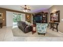 Cozy living room showcasing tile floors, a decorative ceiling fan, and convenient access to the outdoor pool area at 127 Heatherbrooke Cir, Oviedo, FL 32765
