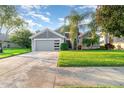 Charming home featuring lush landscaping, a two-car garage, and a well-maintained lawn, all under a bright sky at 1315 Vista Del Lago Blvd, Dundee, FL 33838