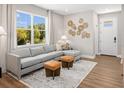 Cozy living room with a gray sectional sofa, decorative wall art, and a large window overlooking the outdoors at 140 Royal Ranch Rd, Clermont, FL 34715