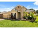 Well-maintained home featuring a manicured lawn and meticulously landscaped garden beds in front of the house at 1507 Alligator St, St Cloud, FL 34771