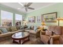 Comfortable living room with a large window, neutral tones, ceiling fan and tastefully framed artwork at 1507 Alligator St, St Cloud, FL 34771