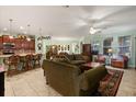 Spacious living area with tile floors, ceiling fan, and open concept layout with a kitchen island and bar stools at 1507 Alligator St, St Cloud, FL 34771