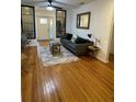 Bright living room with hardwood floors, a gray sofa, and decorative accents near the entry door at 162 Orange Pl, Maitland, FL 32751
