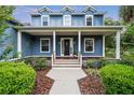 Inviting front porch with decorative columns and wood flooring leads to front door at 16610 County Line Rd, Umatilla, FL 32784