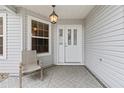 Inviting front porch featuring a chair, decorative light fixture, and front door at 16950 Se 80Th Bellavista Cir, The Villages, FL 32162