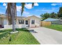 Inviting single-story home featuring a lush green lawn, mature trees, and a concrete driveway with beautiful landscaping at 1920 Dardanelle Dr, Orlando, FL 32808